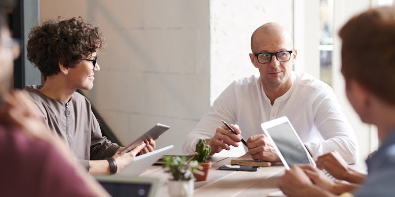 Group of people sitting at a desk discussing strategies for workforce